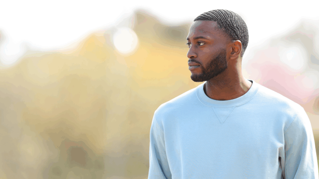 An African-American young man looks off to his right, appearing concerned and undertain.